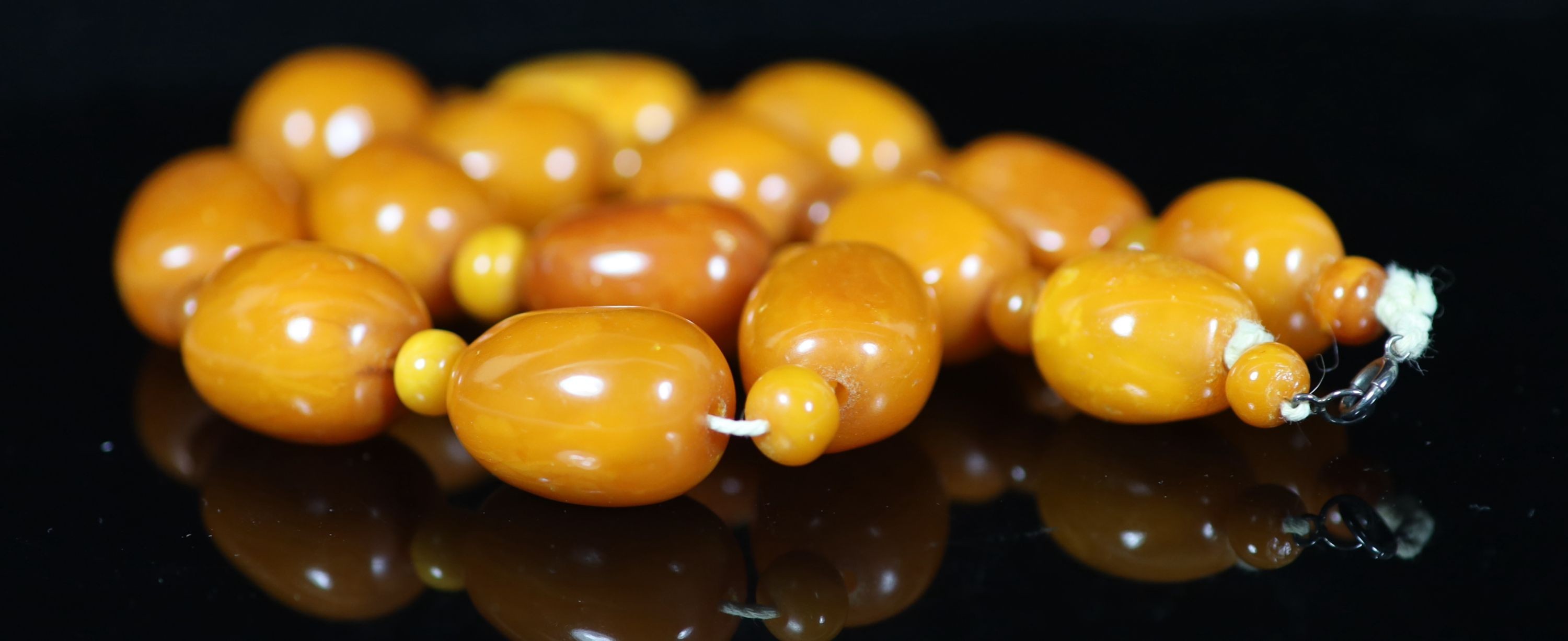 A single stand barrel shaped amber bead necklace, with amber bead spacers